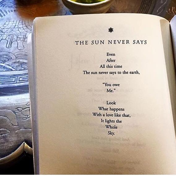 Photo of an open book page. Heading: "THE SUN NEVER SAYS". Poem: "Even / After / All this time / The sun never says to the earth, / "You owe / Me." / Look / What happens / With a love like that, / It lights the / Whole / Sky." A small star ornament sits above the title.