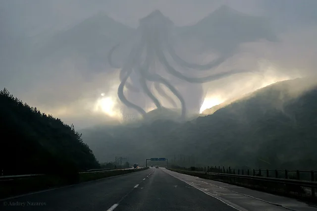 A misty highway curves toward a fog-covered mountain range at dawn. A huge, faint, tentacled winged creature resembling Cthulhu is drawn in the sky above the hills, with the sun glowing beneath it. A few cars travel the road. A watermark in the corner reads "Andrey Nazarov".
