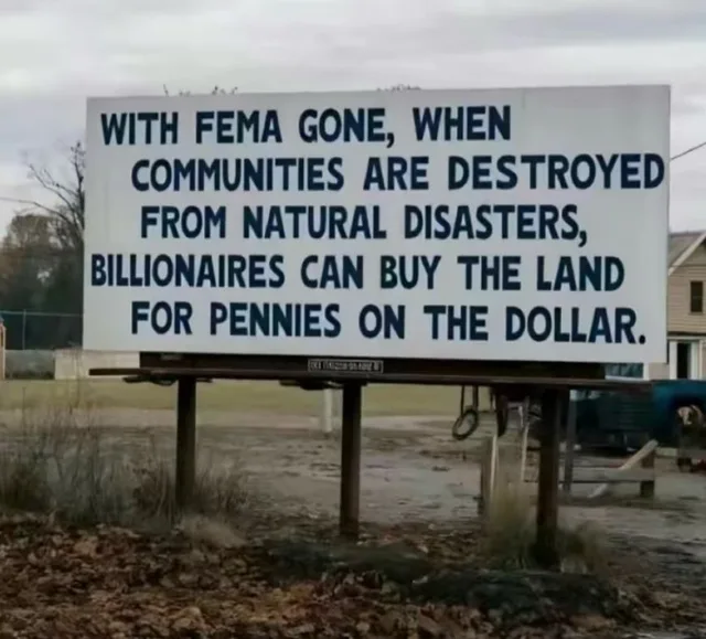 A large white billboard on wooden posts in a muddy, leaf-strewn field under a gray sky. Blue block text reads: "WITH FEMA GONE, WHEN COMMUNITIES ARE DESTROYED FROM NATURAL DISASTERS, BILLIONAIRES CAN BUY THE LAND FOR PENNIES ON THE DOLLAR."