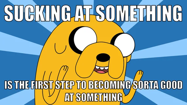 Jake the Dog from Adventure Time, a yellow cartoon dog with wide eyes and raised hands, against a blue sunburst background. Top text: "SUCKING AT SOMETHING". Bottom text: "IS THE FIRST STEP TO BECOMING SORTA GOOD AT SOMETHING".