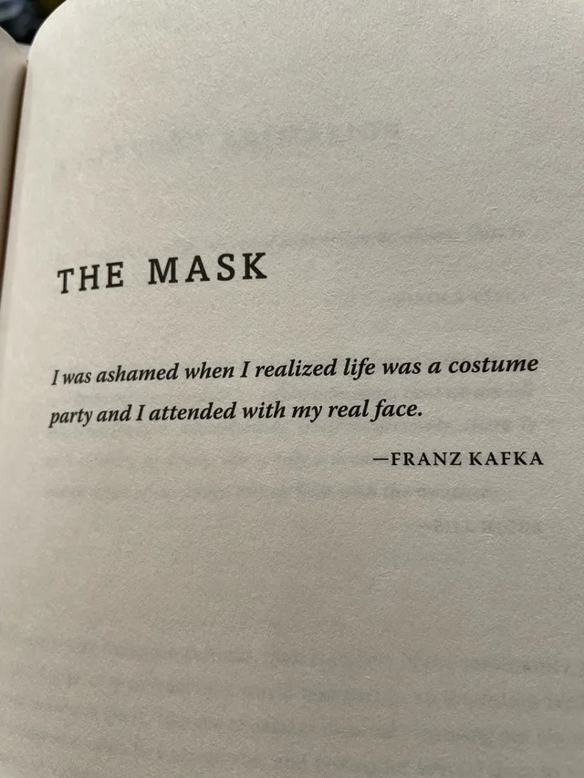 Photo of a book page with the heading "THE MASK" in bold capitals. Below it, in italics: "I was ashamed when I realized life was a costume party and I attended with my real face." Attribution at lower right: "—FRANZ KAFKA".