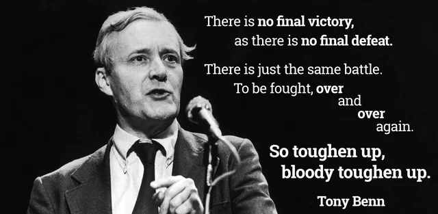 Black-and-white photo of a man with swept-back light hair, wearing a suit jacket and dark tie, speaking at a microphone and pointing. White text on black reads: "There is no final victory, as there is no final defeat. There is just the same battle. To be fought, over and over and over again. So toughen up, bloody toughen up." Signed "Tony Benn".