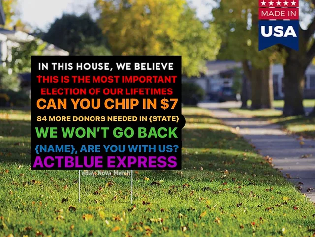 A black yard sign on a grassy lawn by a tree-lined sidewalk, with a Made in USA badge in the corner. Colorful text reads: "IN THIS HOUSE, WE BELIEVE" "THIS IS THE MOST IMPORTANT ELECTION OF OUR LIFETIMES" "CAN YOU CHIP IN $7" "84 MORE DONORS NEEDED IN {STATE}" "WE WON'T GO BACK" "{NAME}, ARE YOU WITH US?" "ACTBLUE EXPRESS". Faint watermark: eBay Nova Merch.