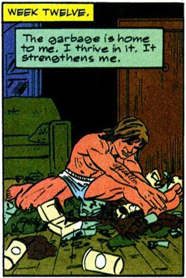 Comic panel of a shirtless, muscular long-haired man in blue underwear crouched on a wooden floor littered with trash and cups, a green couch behind him. Yellow caption: "WEEK TWELVE." Narration box: "The garbage is home to me. I thrive in it. It strengthens me."